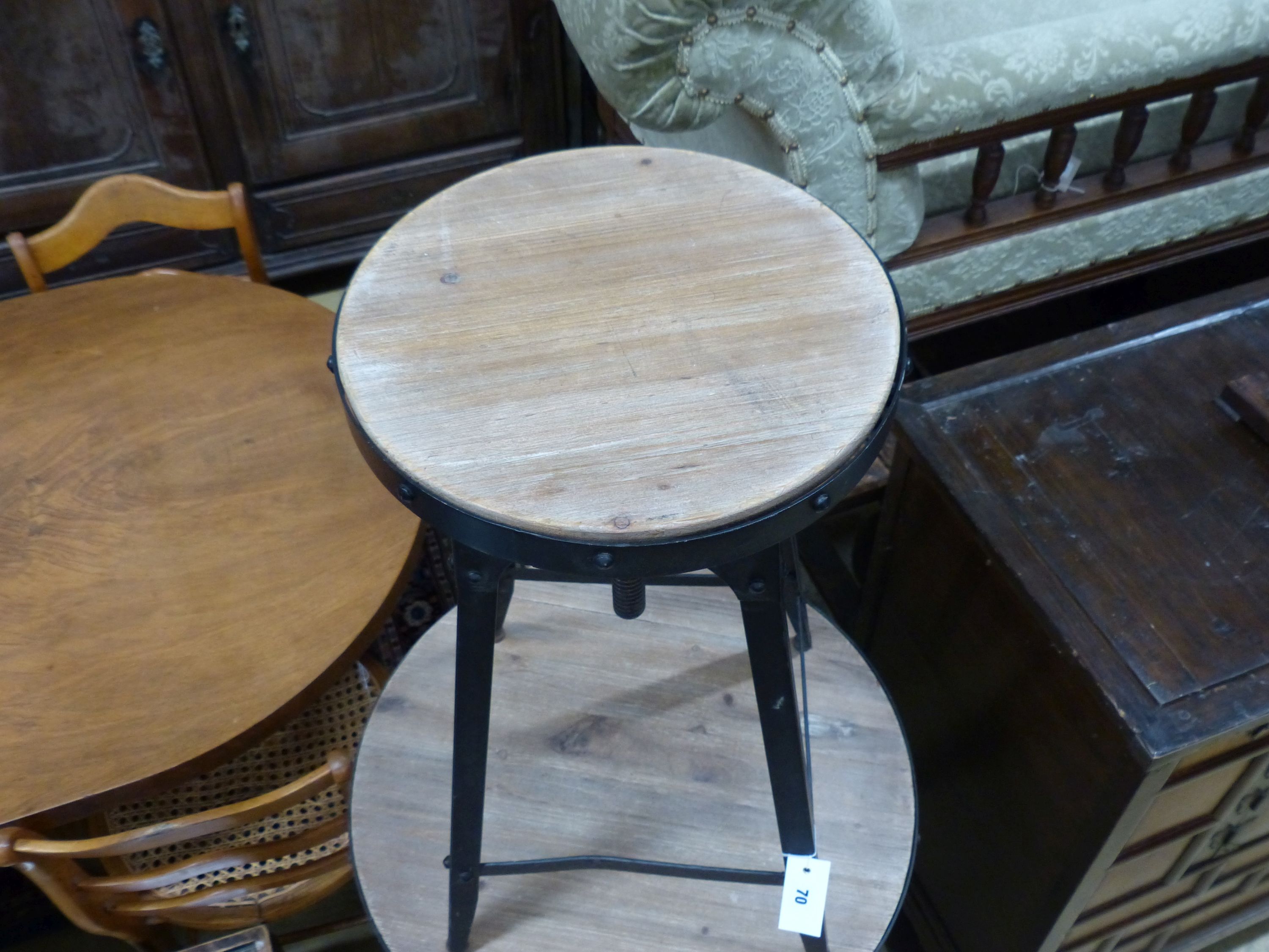 An adjustable wrought iron pub table and three matching telescopic stools